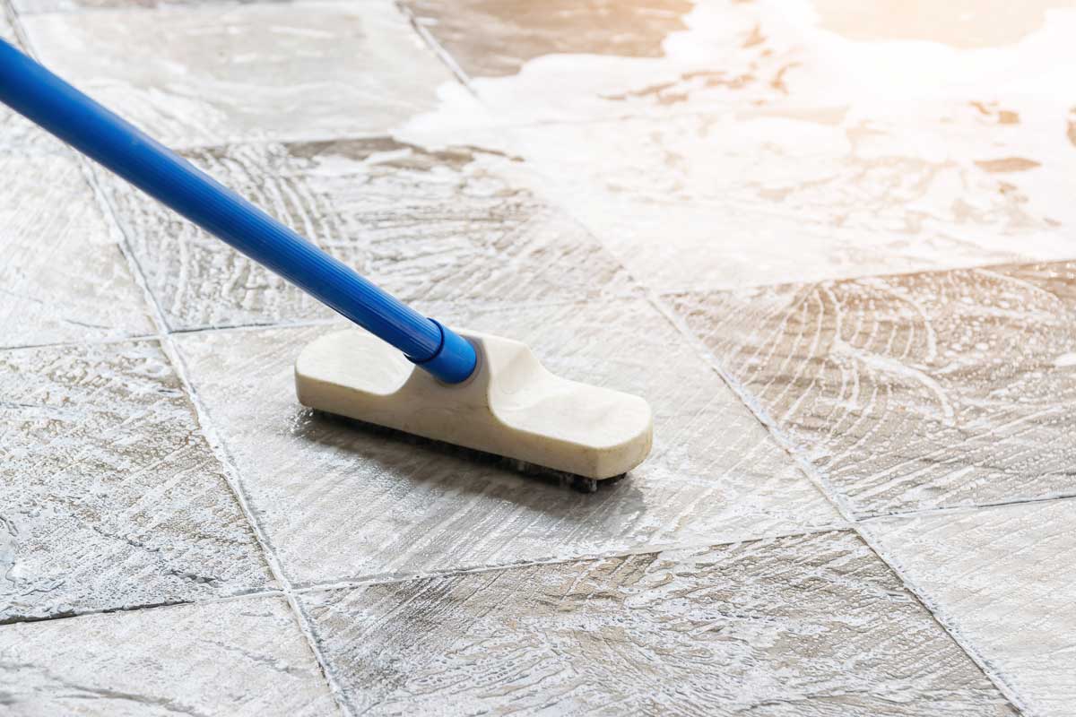 Cleaning The Tile Floor With Floor Scrubber Brush And Water cleaning services
